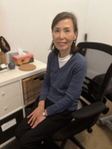 Kang Ja Lee, Acupuncturist, sitting in her chair